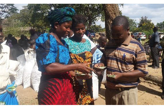 A small holder women farmer receiving payment from CPM-Agri Enterprises towards sale of seed under seed village model in Chadza